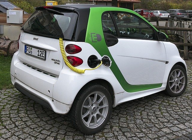 A green truck parked in front of a car